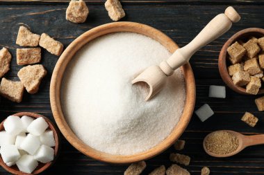 Tahta arka planda farklı şekerli kaseler, üst manzara