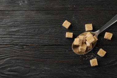 Tahta zemin üzerinde şeker küpleri olan kaşık, üst görünüm