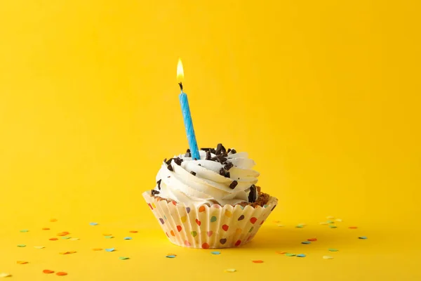 Cupcake with candle on yellow background, space for text — Stock Photo, Image