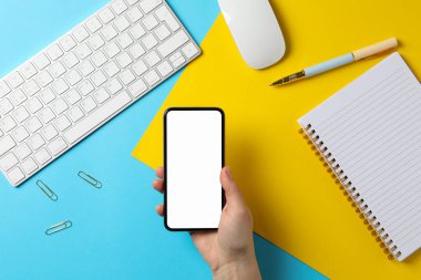 Telefonu boş ekranlı bir kadın tutuyor. İş yeri. İki - ton ba