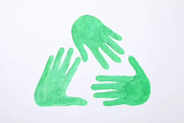 Cartel de reciclaje hecho de manos verdes sobre fondo blanco, vista superior — Foto de Stock