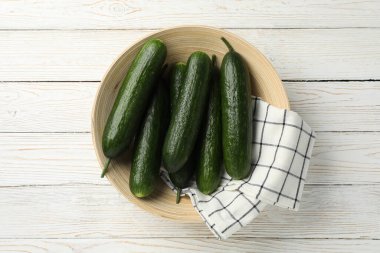 Ahşap arka planda salatalıklı kase, üst manzara.