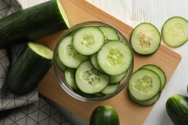 Ahşap zemin üzerinde salatalık ve havlu olan tahta, üst görünüm.