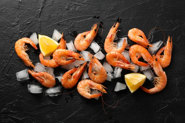 Shrimps, lemon and ice on black background, top view — 스톡 사진