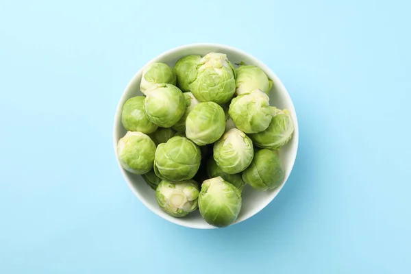 Schale mit Rosenkohl auf blauem Hintergrund, Ansicht von oben — Stockfoto