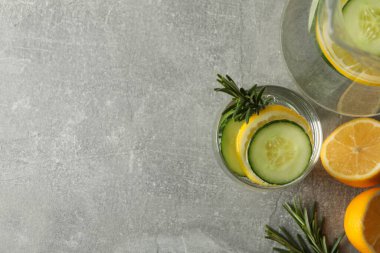 Gri masada salatalık suyu olan sürahi ve cam, üst manzara.