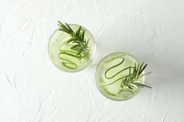 Beyaz zemin üzerinde salatalık suyu olan bardaklar, üst görünüm