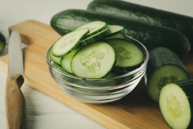 Ahşap zemin üzerinde salatalık ve bıçak olan tahta, kapat.