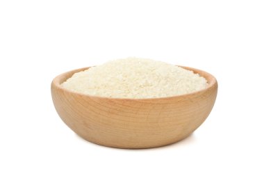 Beyaz zemin üzerinde pirinç bulunan ahşap bir kase.