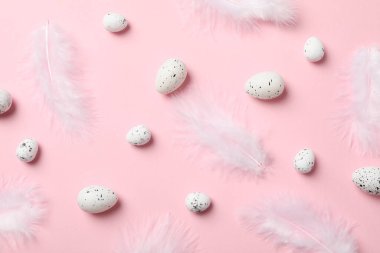 Pembe arka planda yumurtalar ve tüyler, üst manzara