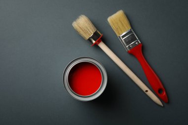 Siyah zemin üzerinde kırmızı boya ve fırça kutusu, üst görünüm