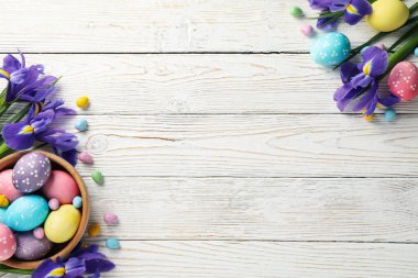 Paskalya yumurtaları ve ahşap zemin üzerinde Iris çiçekleri olan kompozisyon, metin için boşluk