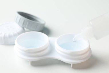 Beyaz arkaplanda kontak lensler ve sıvı, kapatın