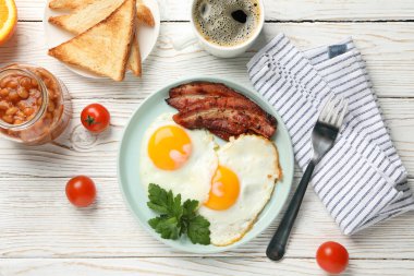 Lezzetli kahvaltı ya da beyaz ahşap arka planda kızarmış yumurtalarla öğle yemeği.