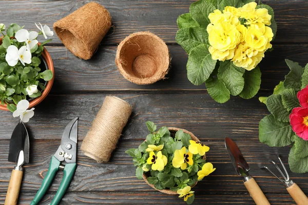 Ahşap arka planda çiçek ve bahçe araçları, üst görünüm