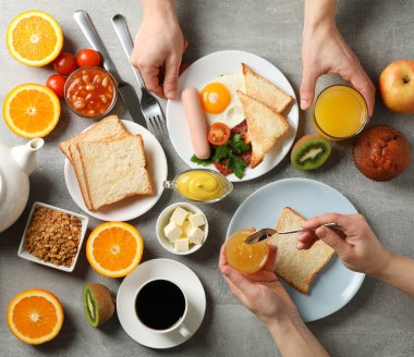 Lezzetli kahvaltı ya da öğle yemeği geçmişi. Gri masa. İnsanlar yer.