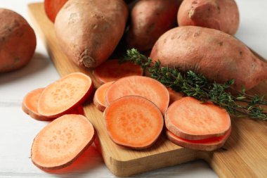 Tatlı patates, kekik ve tahta kaplama beyaz ahşap arka plan, kapat