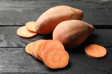 Tahta arka planda tatlı patates, yakın plan. Sebzeler