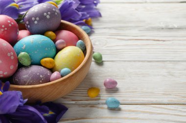 Paskalya yumurtaları ve ahşap zemin üzerinde Iris çiçekleri olan kompozisyon, metin için boşluk