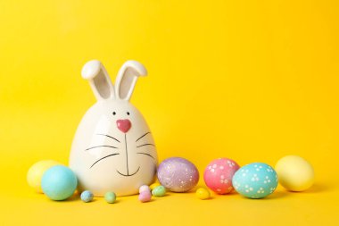 Sarı arka planda tavşan ve paskalya yumurtaları, metin için boşluk