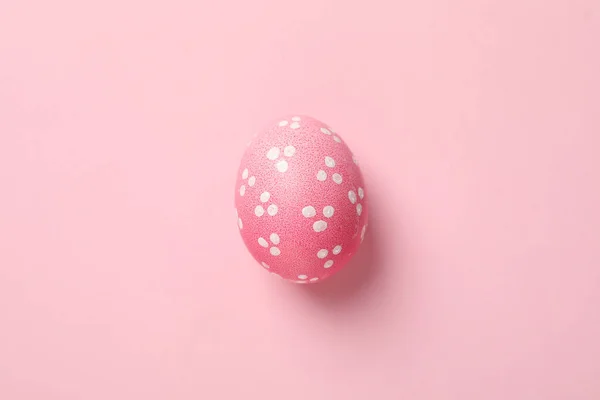 Pink Easter egg on pink background, close up