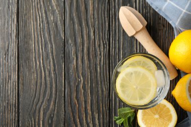 Bardakta limonata ve ahşap arka planda malzemeler var.