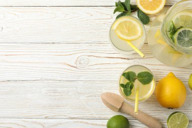 Ahşap arka planda farklı bardaklarda taze limonata.
