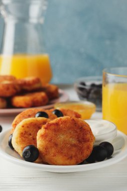 Beyaz ahşap arka planda peynirli krep kahvaltısı.