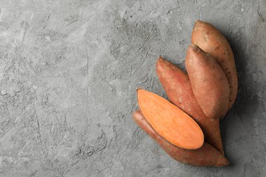 Gri arka planda tatlı patates, üst manzara. Sebzeler