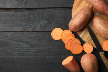 Tahta arka planda tatlı patates, üst manzara. Sebzeler