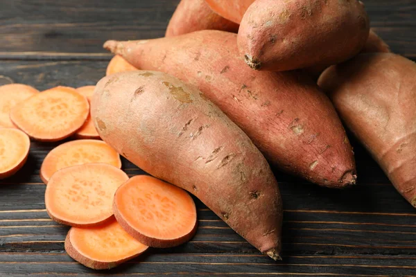 Tahta arka planda tatlı patates, yakın plan.