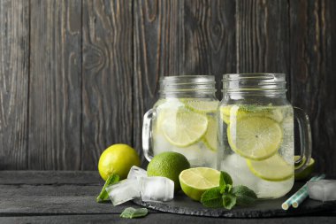 Ahşap zemin üzerinde limonata olan cam kavanozlar. Taze içecek.