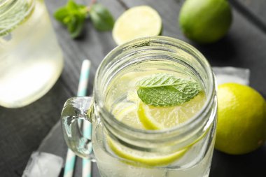 Koyu ahşap arka planda limonata olan cam kavanozlar.