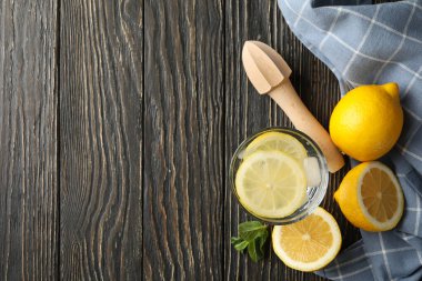 Bardakta limonata ve ahşap arka planda malzemeler var.
