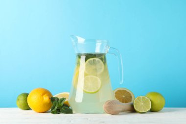 Mavi arka planda limonatalı sürahi. Taze içecek.