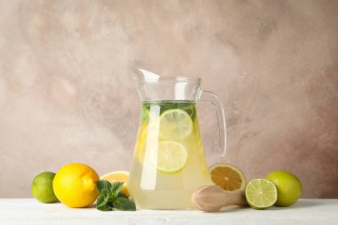 Tahta masada limonata ve malzemelerle dolu bir sürahi. Taze içecek.