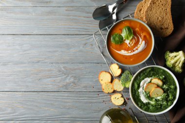 Tahta arka planda tatlı patates ve brokoli kremalı çorba.