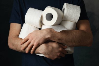 Adamın elinde tuvalet kağıdı ruloları var.