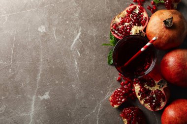 Kahverengi arkaplanda nar ve meyve suyu, metin için üst görünüm ve boşluk