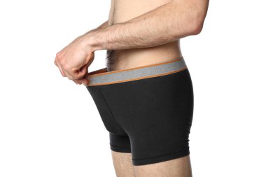 Bir adam donunun içine bakar, beyaz arka planda soyutlanmış.