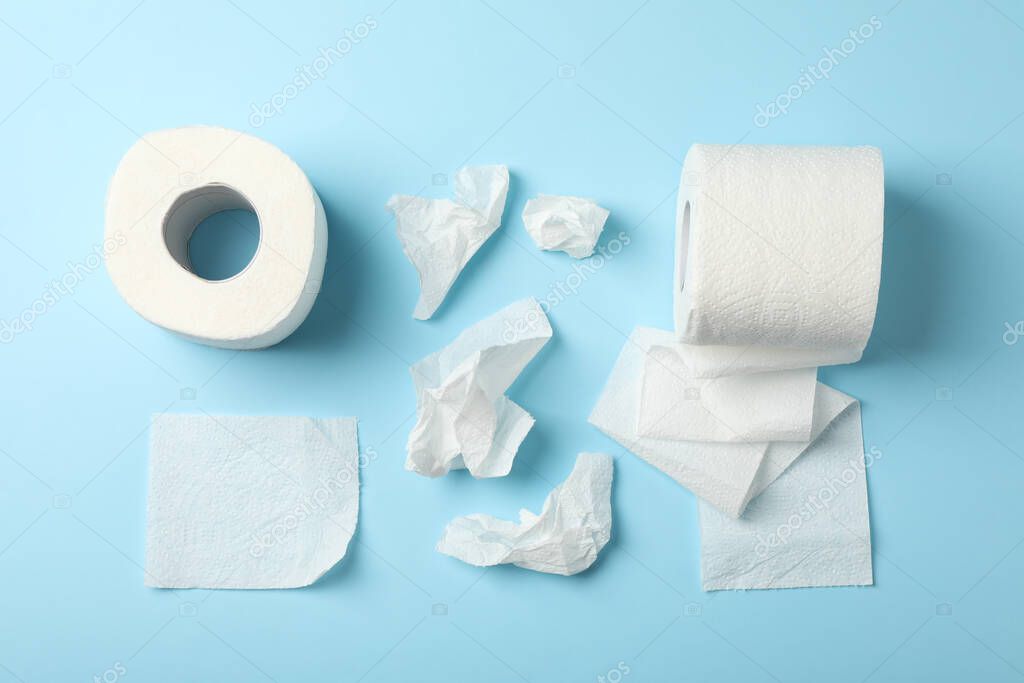 Flat lay with toilet paper on blue background, top view