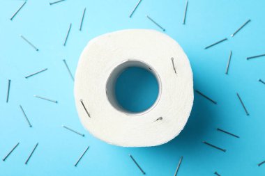 Mavi arka planda tuvalet kağıdı ve çiviler, üst görünüm