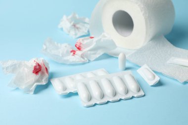 Tuvalet kağıdı, mumlar ve kağıt, mavi arka planda kan var, kapat.