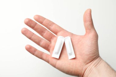 Beyaz arka planda anal ya da vajinal mumlar olan el, kapat