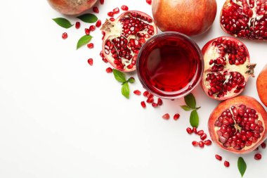 Beyaz zemin üzerinde nar, meyve suyu ve tohumlar, üst görünüm