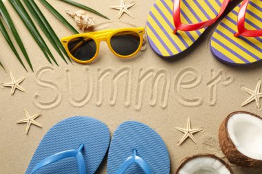 Tatil aksesuarları ve yazıtları olan kompozisyon Deniz kumu arka planında yaz