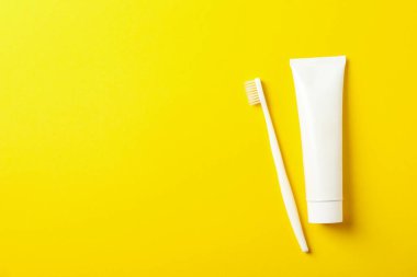 Sarı arkaplanda diş fırçası ve diş macunu, metin için boşluk