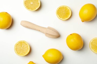 Limonlar ve ahşap sıkacağı beyaz arka planda, üst manzara. Olgun meyve