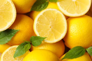 Arka planda yaprakları olan limonlar, yaklaşın. Olgun meyve