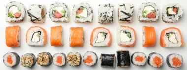 Beyaz zemin üzerinde suşi ruloları ile düz yatıyordu. Japon yemeği.
